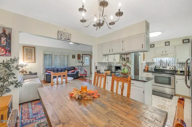 a living room with furniture kitchen view and a chandelier