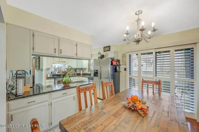 a kitchen with stainless steel appliances wooden floor dining table and chairs