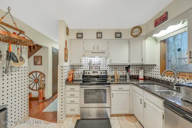 a kitchen with stainless steel appliances a stove and cabinets