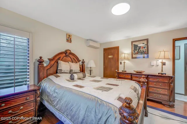 a bedroom with a bed and dresser with mirror