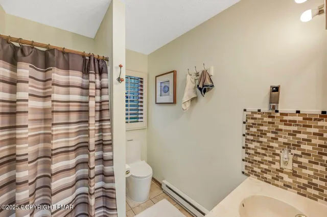 a bathroom with a toilet and a shower curtain