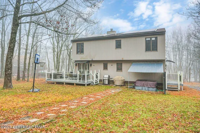 a house view with swimming pool and trees in the background