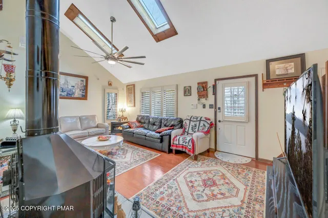 a living room with furniture a flat screen tv and a table