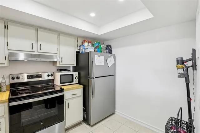 a kitchen with a refrigerator and a stove top oven