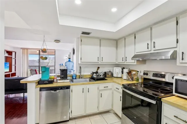 a kitchen with stainless steel appliances a stove a sink and cabinets