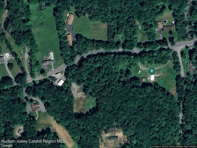 an aerial view of residential house with outdoor space and trees all around