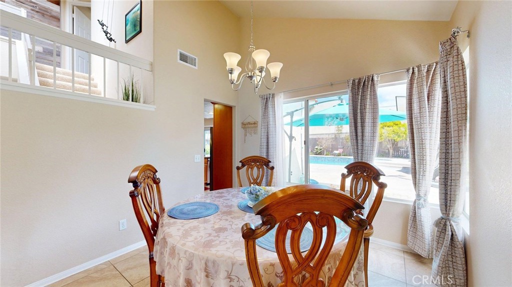 794 Banyonwood Drive Oceanside, CA 92057 - Photo 18 of 62 a view of a dining room with furniture a chandelier and wooden floor