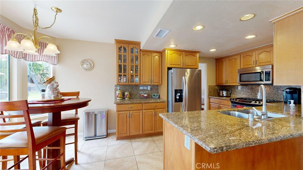 794 Banyonwood Drive Oceanside, CA 92057 - Photo 23 of 62 a kitchen with stainless steel appliances granite countertop a sink counter space and a dining table