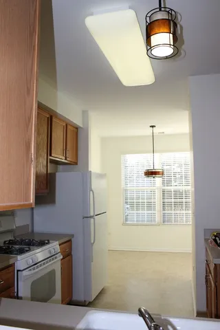 a kitchen with stainless steel appliances granite countertop a stove a sink and a refrigerator