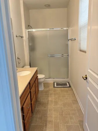 a bathroom with a granite countertop sink toilet and shower