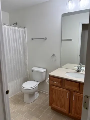 a bathroom with a sink a toilet a mirror and shower