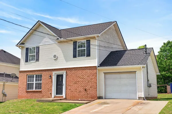 a front view of a house with a yard and garage