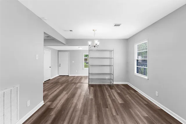a view of empty room with wooden floor and window