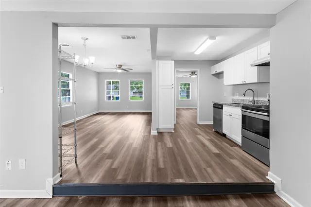 a kitchen view with wooden floor and windows