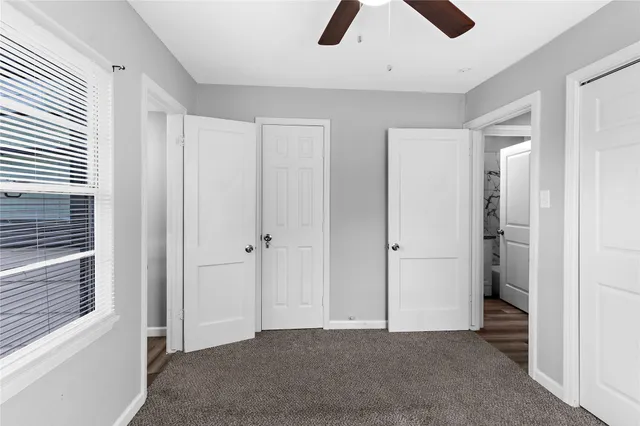 an empty room with fan and windows