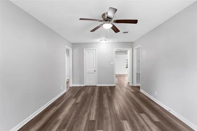 a view of a big room with wooden floor and windows
