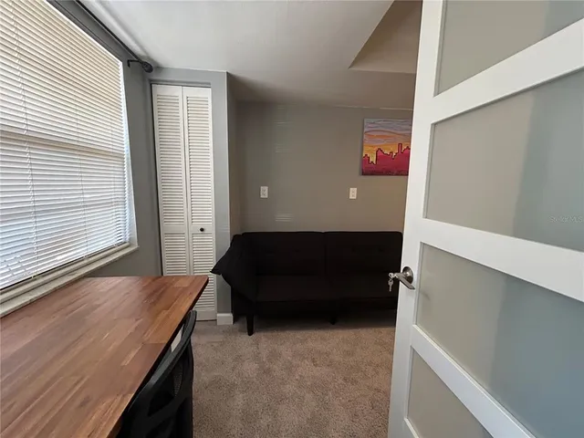 a living room with furniture and a floor to ceiling window