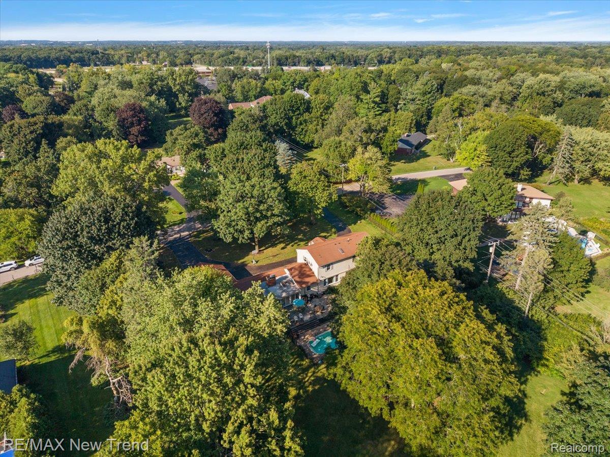 1450 Lenox Road Bloomfield Hills, MI 48304 - Photo 78 of 79 Aerial perspective showcasing extensive tree coverage, a residential property with a light-colored exterior, and an in-ground swimming pool