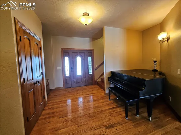 a room with wooden floor pool table and windows
