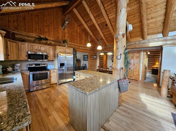 a kitchen with stainless steel appliances wooden cabinets a sink and a refrigerator