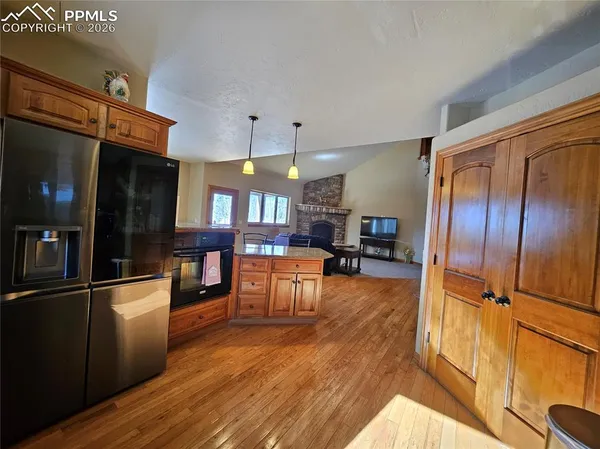 a kitchen with stainless steel appliances wooden floor and large windows