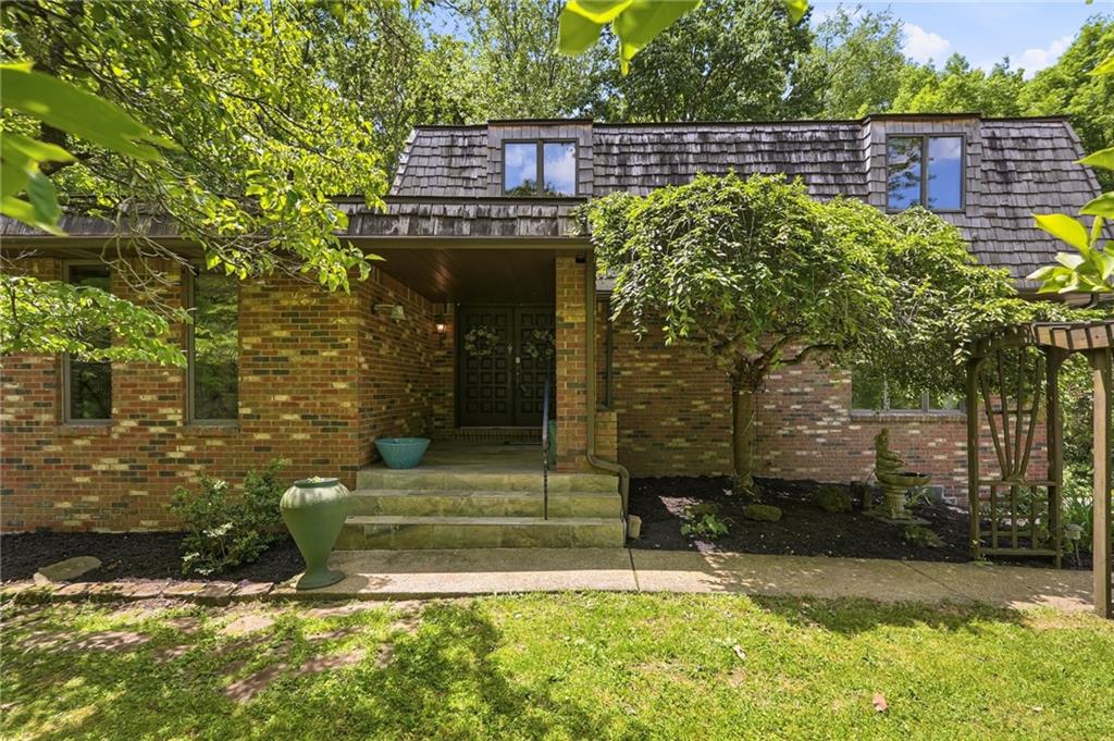 a view of a house with a small yard plants and large tree