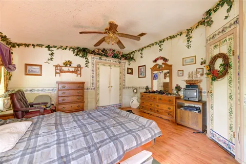 a bedroom with a bed and dresser with the bathroom