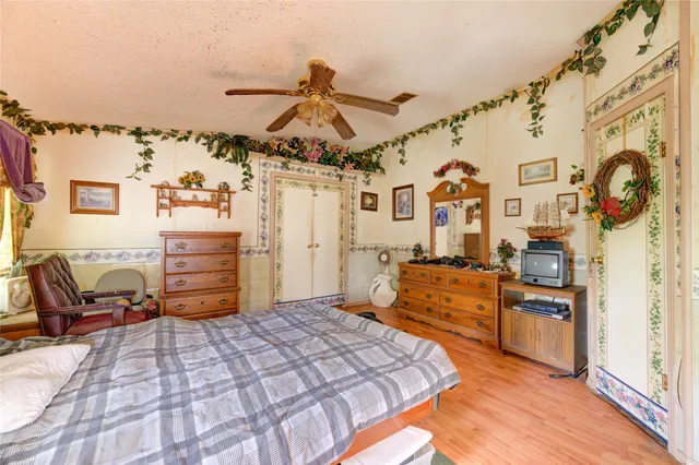 a bedroom with a bed and dresser with the bathroom