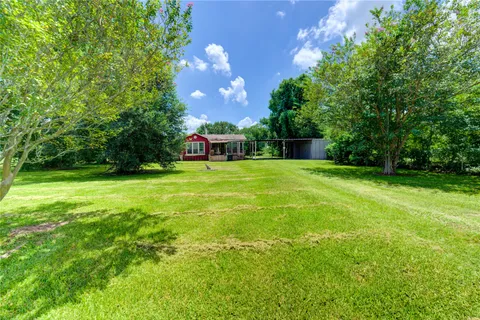 a view of a ground with huge green field and trees