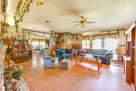a living room with furniture kitchen view and a large window