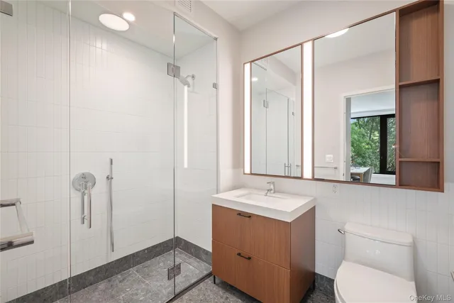 a bathroom with a granite countertop sink toilet and shower