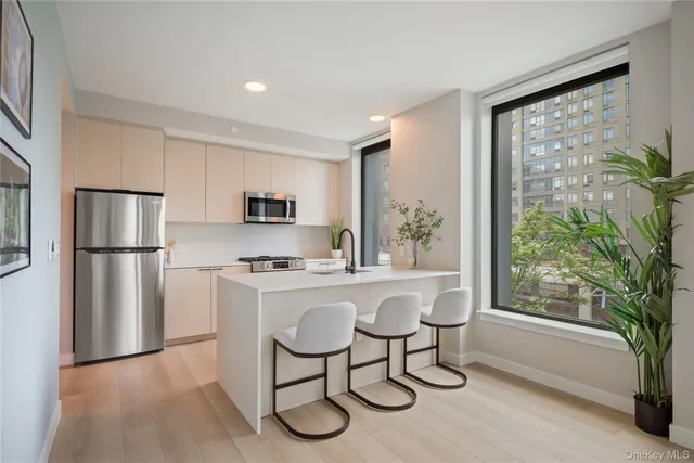 a kitchen with a refrigerator a stove a sink cabinets and a dining table