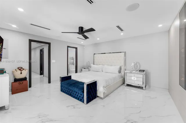 a bedroom with a large bed and a chandelier