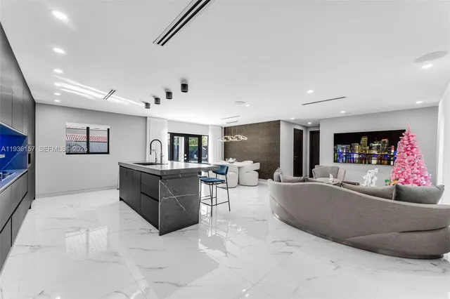 a large kitchen with stainless steel appliances a large counter top a stove and a sink