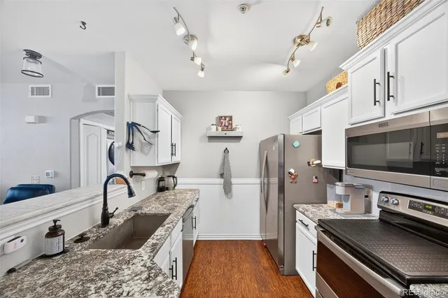 a kitchen with stainless steel appliances granite countertop a refrigerator and a stove top oven