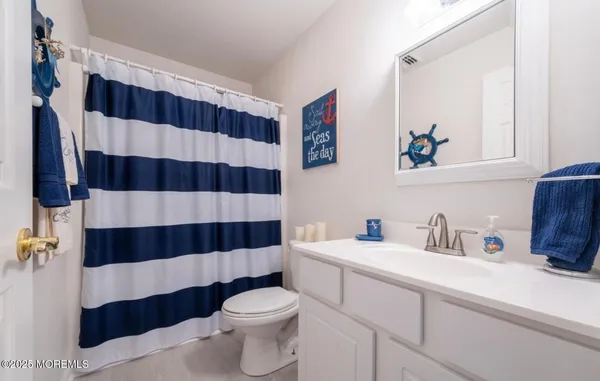a bathroom with a sink a toilet and a shower curtain