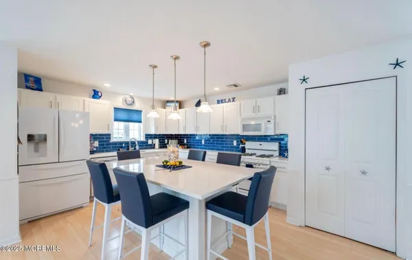 a kitchen with refrigerator and chairs