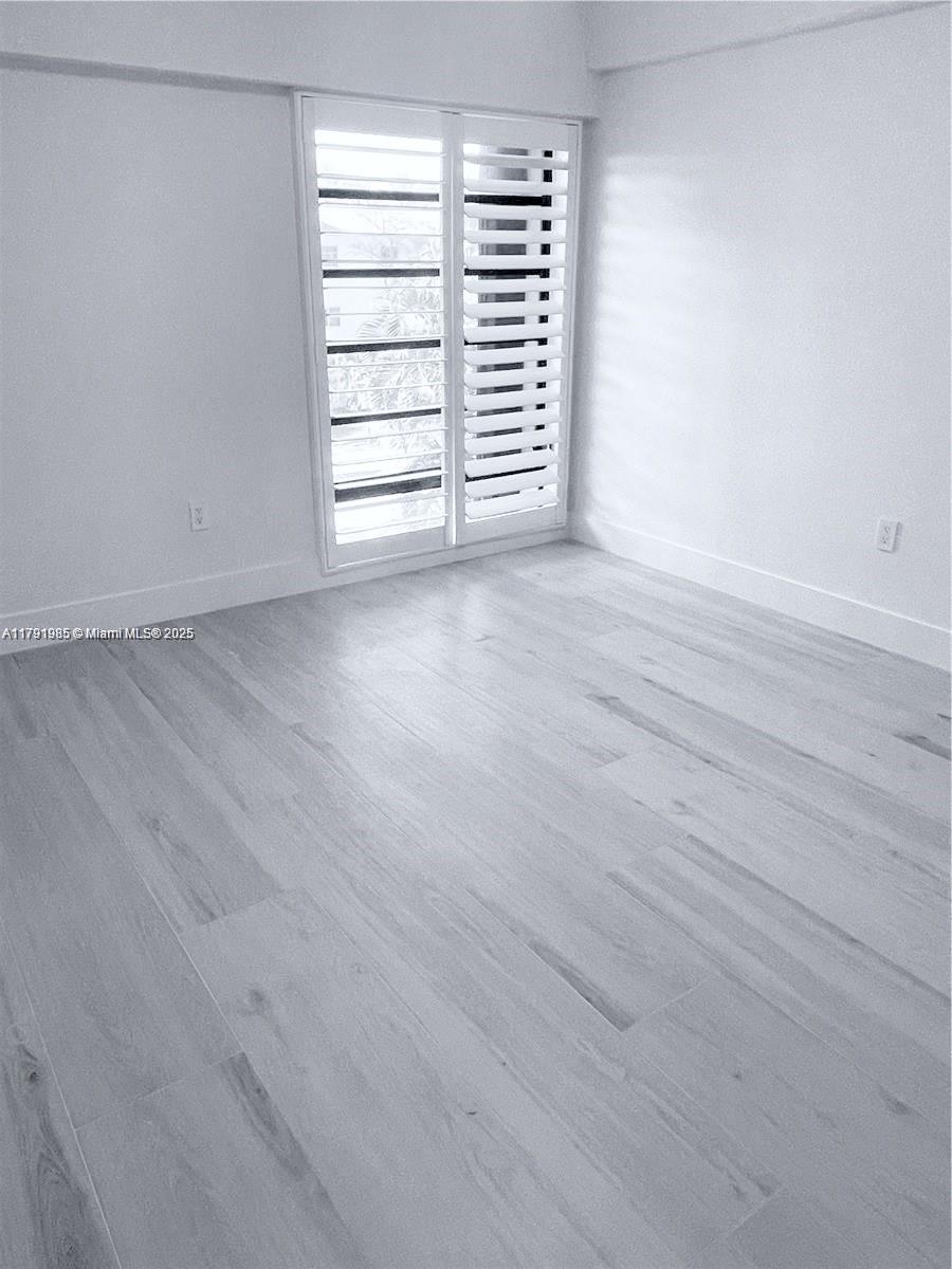 575 Crandon Boulevard, Unit 307 Key Biscayne, FL 33149 - Photo 12 of 37 an empty room with wooden floor and windows