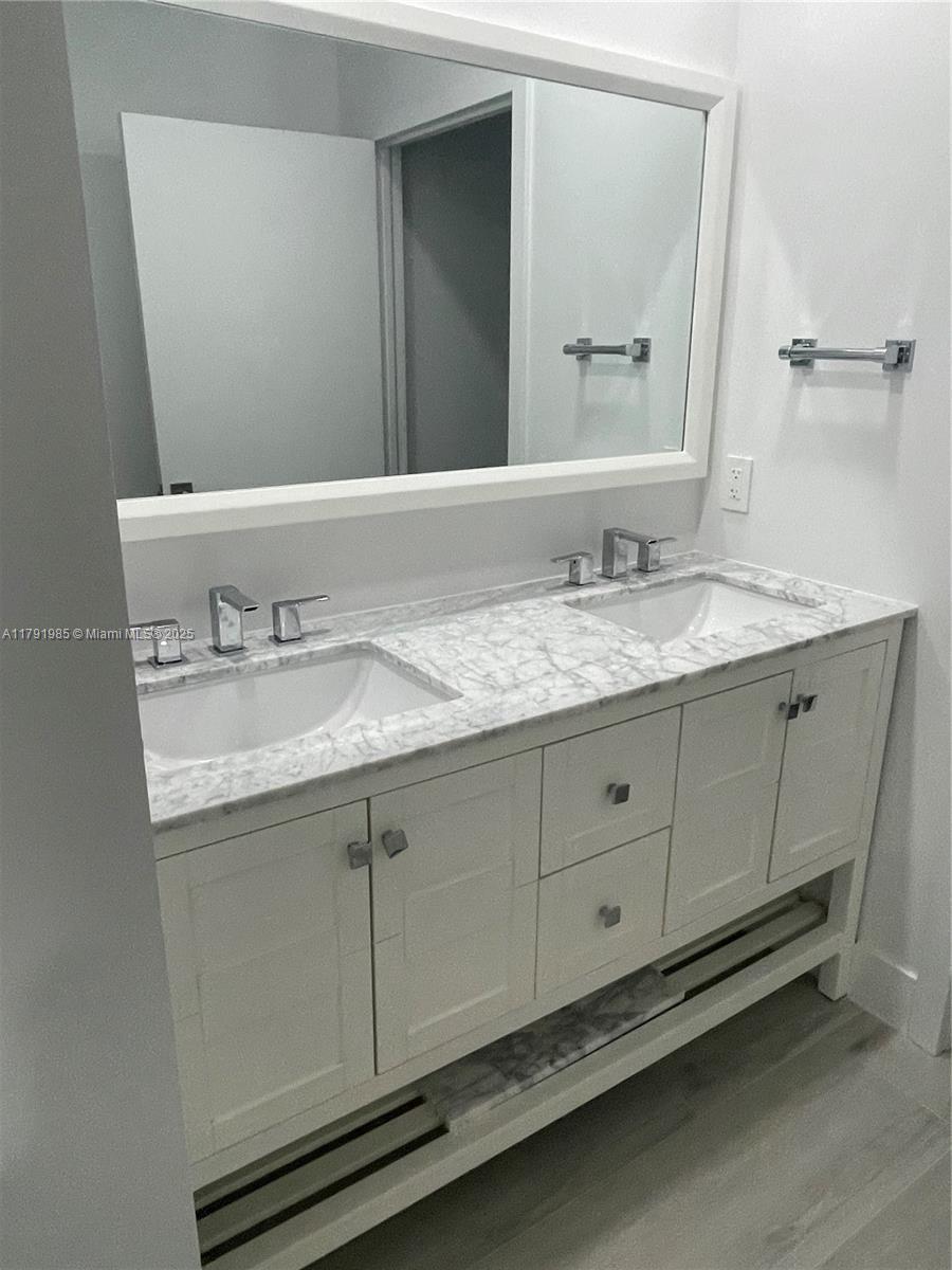 575 Crandon Boulevard, Unit 307 Key Biscayne, FL 33149 - Photo 7 of 37 a bathroom with a granite countertop sink and a mirror
