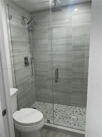 a bathroom with a toilet and a shower