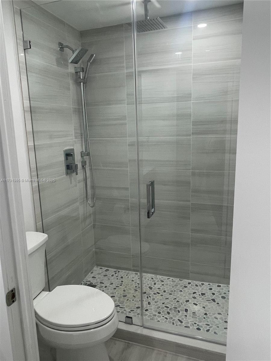 575 Crandon Boulevard, Unit 307 Key Biscayne, FL 33149 - Photo 9 of 37 a bathroom with a toilet and a shower