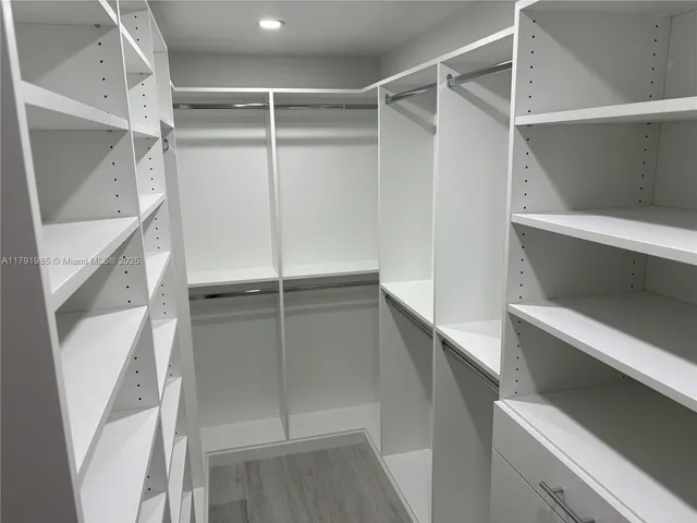 a view of walk in closet with empty racks