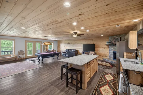a room with furniture pool table wooden floor and windows