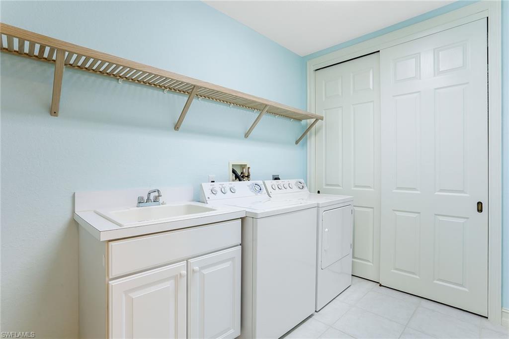 8609 Champions Point, Unit 201 Naples, FL 34113 - Photo 13 of 25 a utility room with dryer and washer