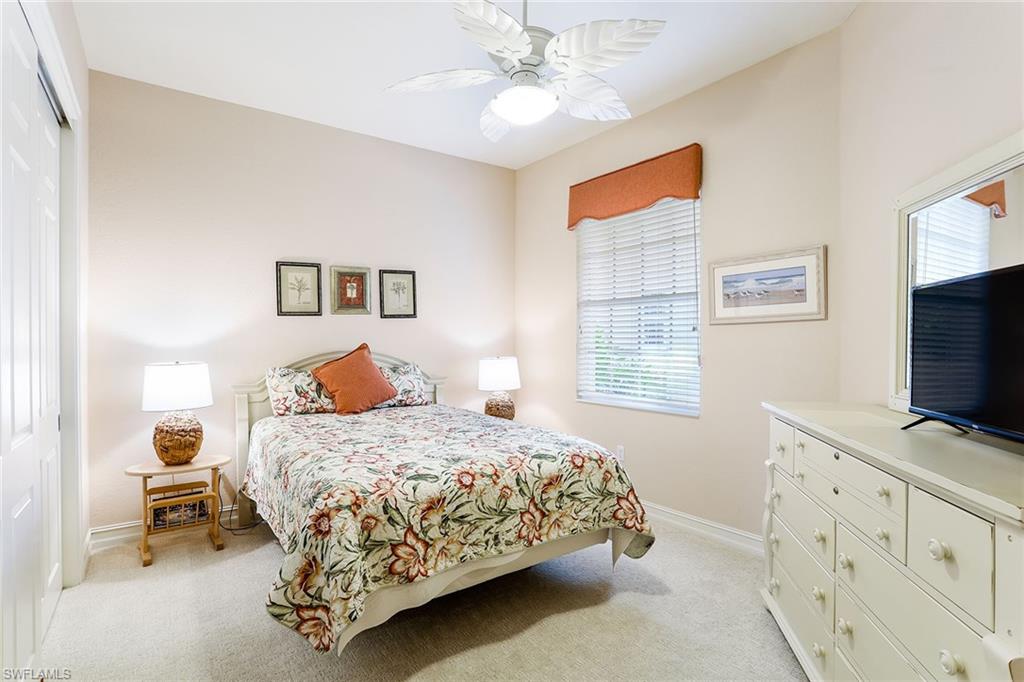 8609 Champions Point, Unit 201 Naples, FL 34113 - Photo 14 of 25 a bedroom with a bed and a flat tv screen on dresser