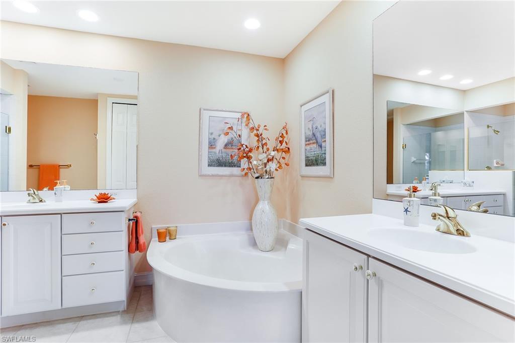 8609 Champions Point, Unit 201 Naples, FL 34113 - Photo 15 of 25 a bathroom with a sink and a mirror