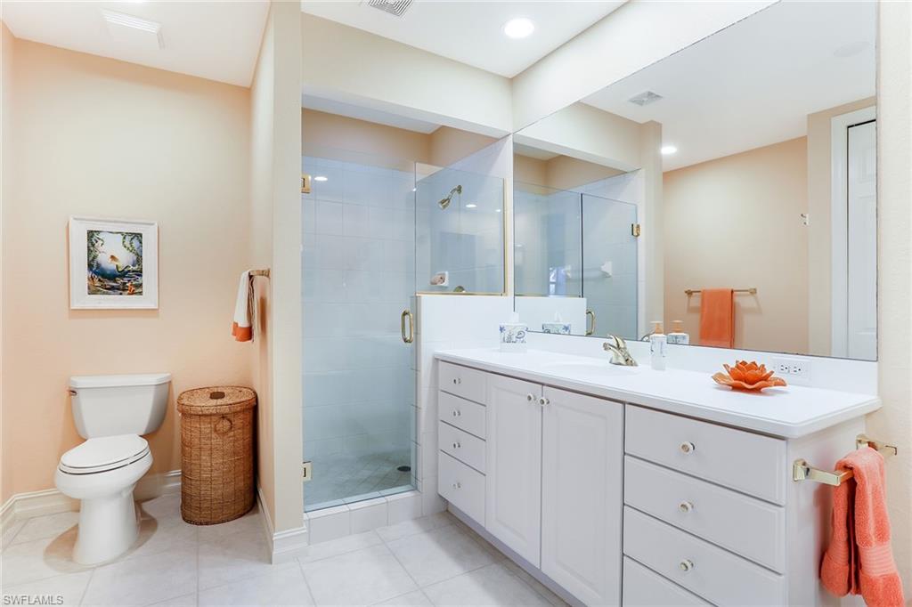 8609 Champions Point, Unit 201 Naples, FL 34113 - Photo 16 of 25 a spacious bathroom with a toilet sink and mirror
