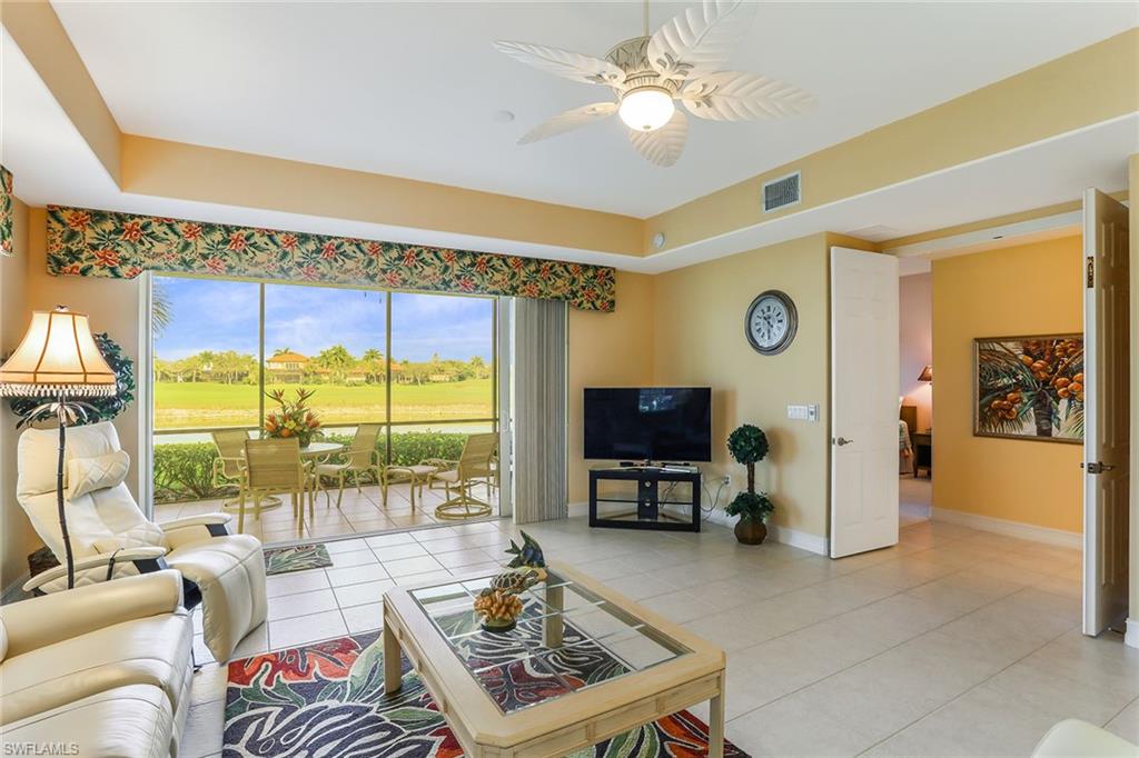 8609 Champions Point, Unit 201 Naples, FL 34113 - Photo 20 of 25 a living room with furniture a flat screen tv and a window