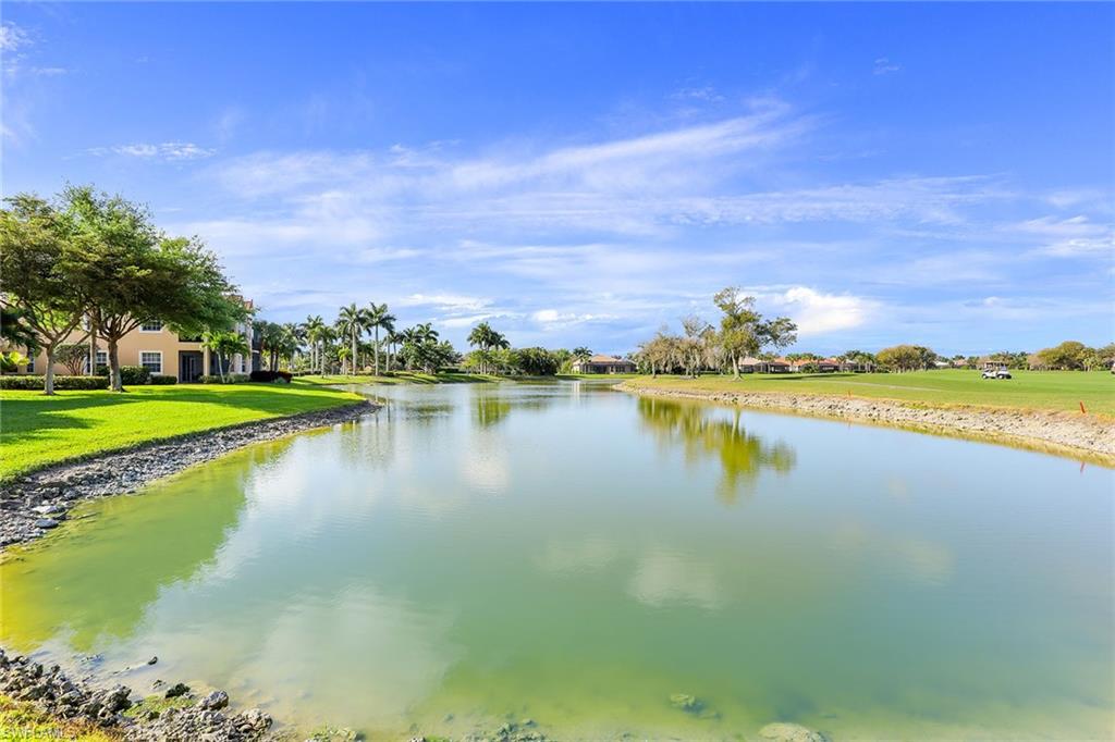 8609 Champions Point, Unit 201 Naples, FL 34113 - Photo 24 of 25 a view of a lake with houses in the back