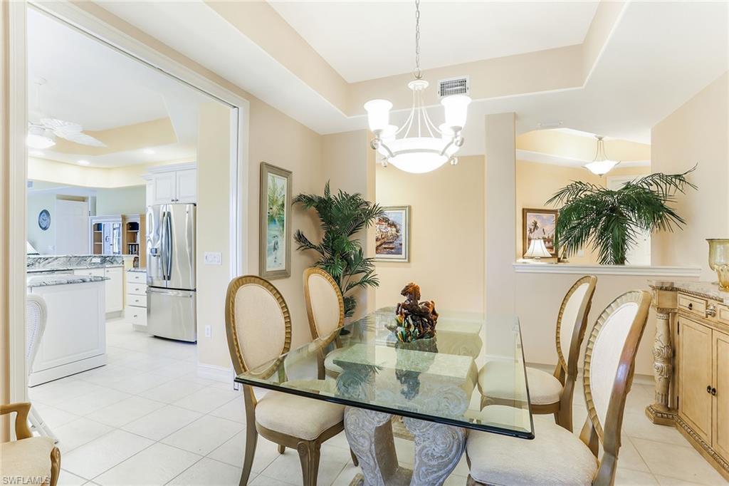 8609 Champions Point, Unit 201 Naples, FL 34113 - Photo 7 of 25 a view of a dining room with furniture and chandelier
